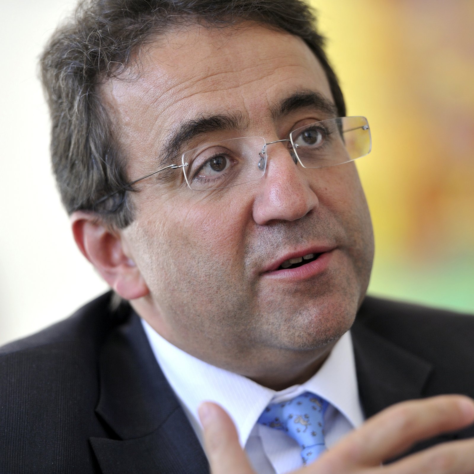 Ein Mann in den Fünfzigern im Anzug mit Brille